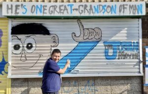 Justin stood in front of the design he has painted on the Partisan shutter.