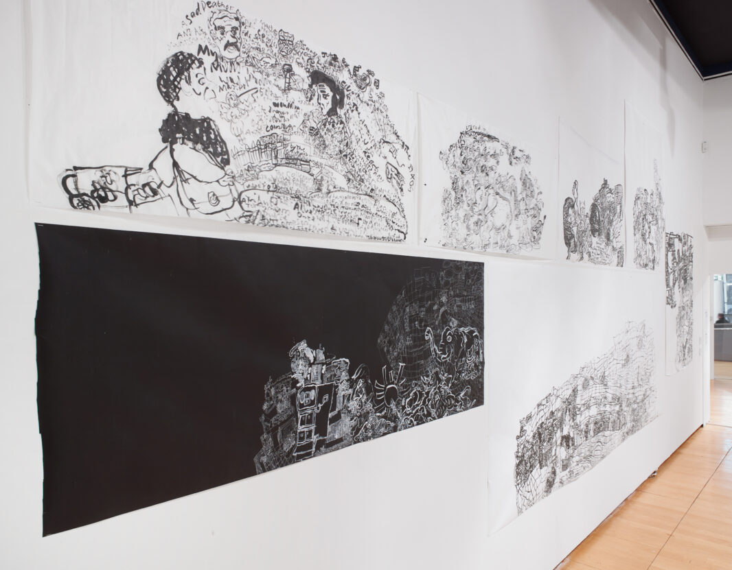 Black and white illustrations on a gallery wall.