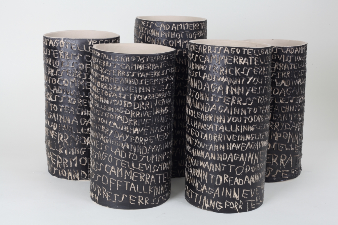 Ceramic cylinders inscribed with text by artist Barry Finan.