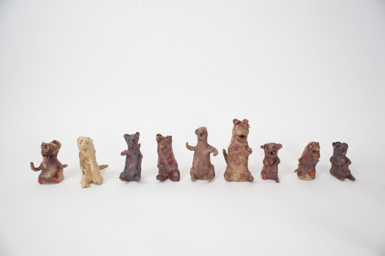 9 ceramic weasels standing a row