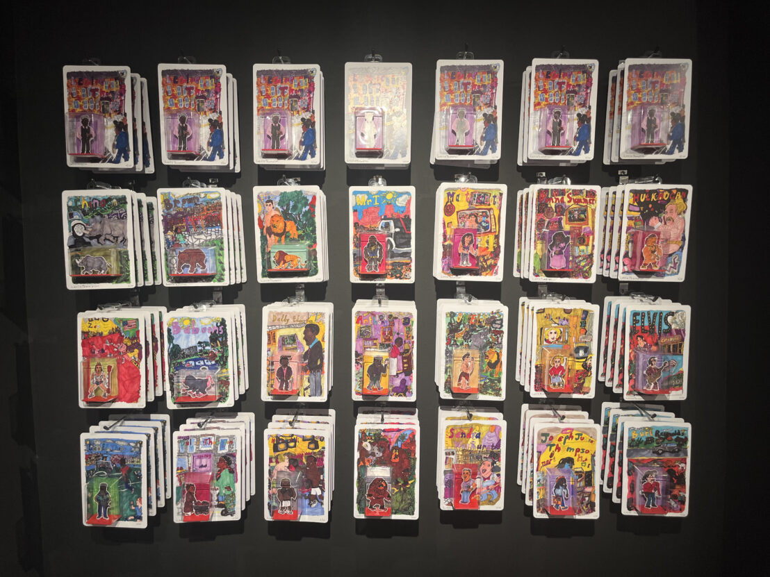 Leslie Thompson's limited edition figures, displayed in a grid on a black wall at the YESS LAD exhibition