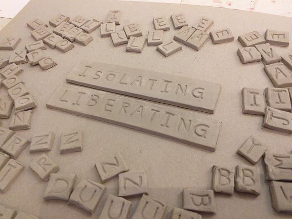 Letter bricks created by James Desser - in the centre are two longer pieces with the words 'isolating' and 'liberating'