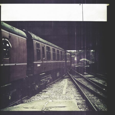 Aged or Old Photograph of train carriage leaving a station. Dark muted colours.