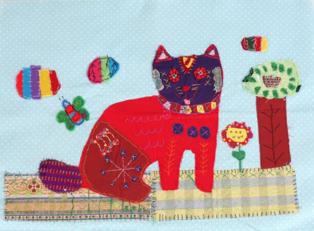 Textile artwork by Chelsea Dalton of a red cat against a blue background, with embroidered details