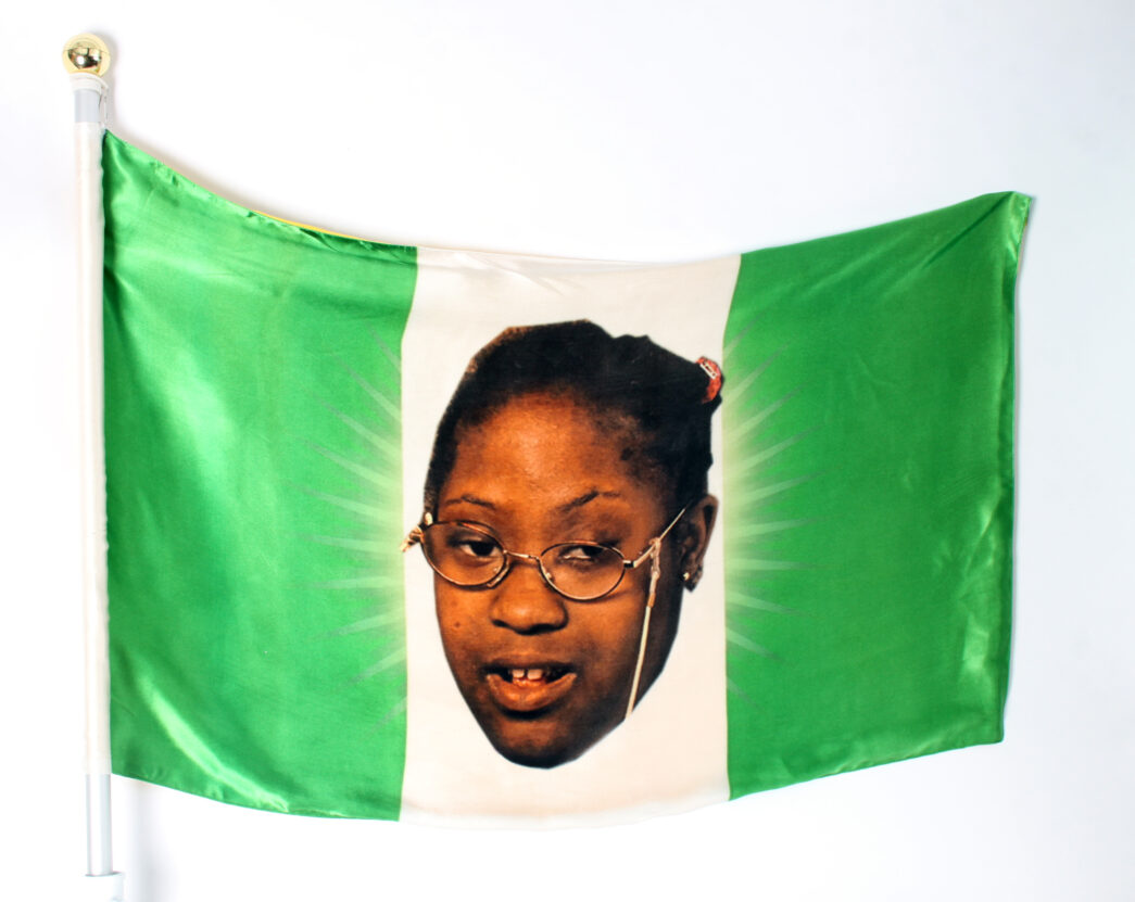 White and green flag with three vertical stripes and a photograph of a face in the middle