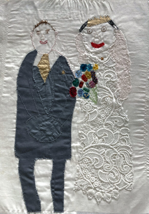 Embroidered image of a couple on their wedding day.