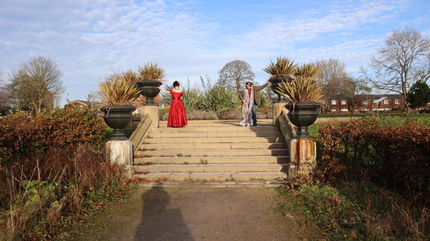 Joe Mills and Ruby Tingle pose at the top of a flight of stairs in a big garden