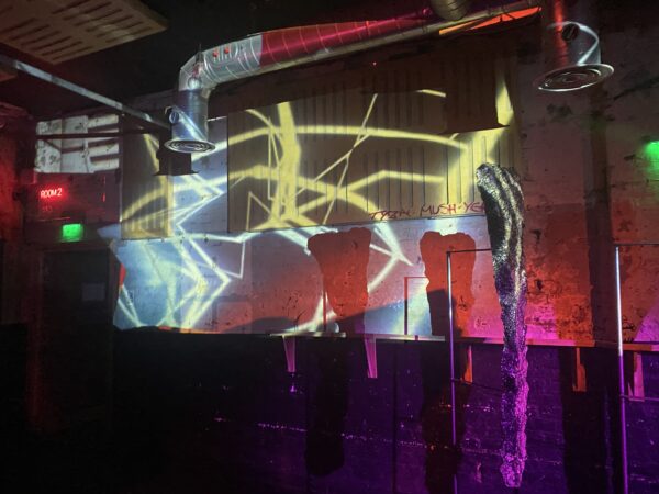 Lights projected onto a wall, during a projection mapping performance by Malik Jama at SOUP event