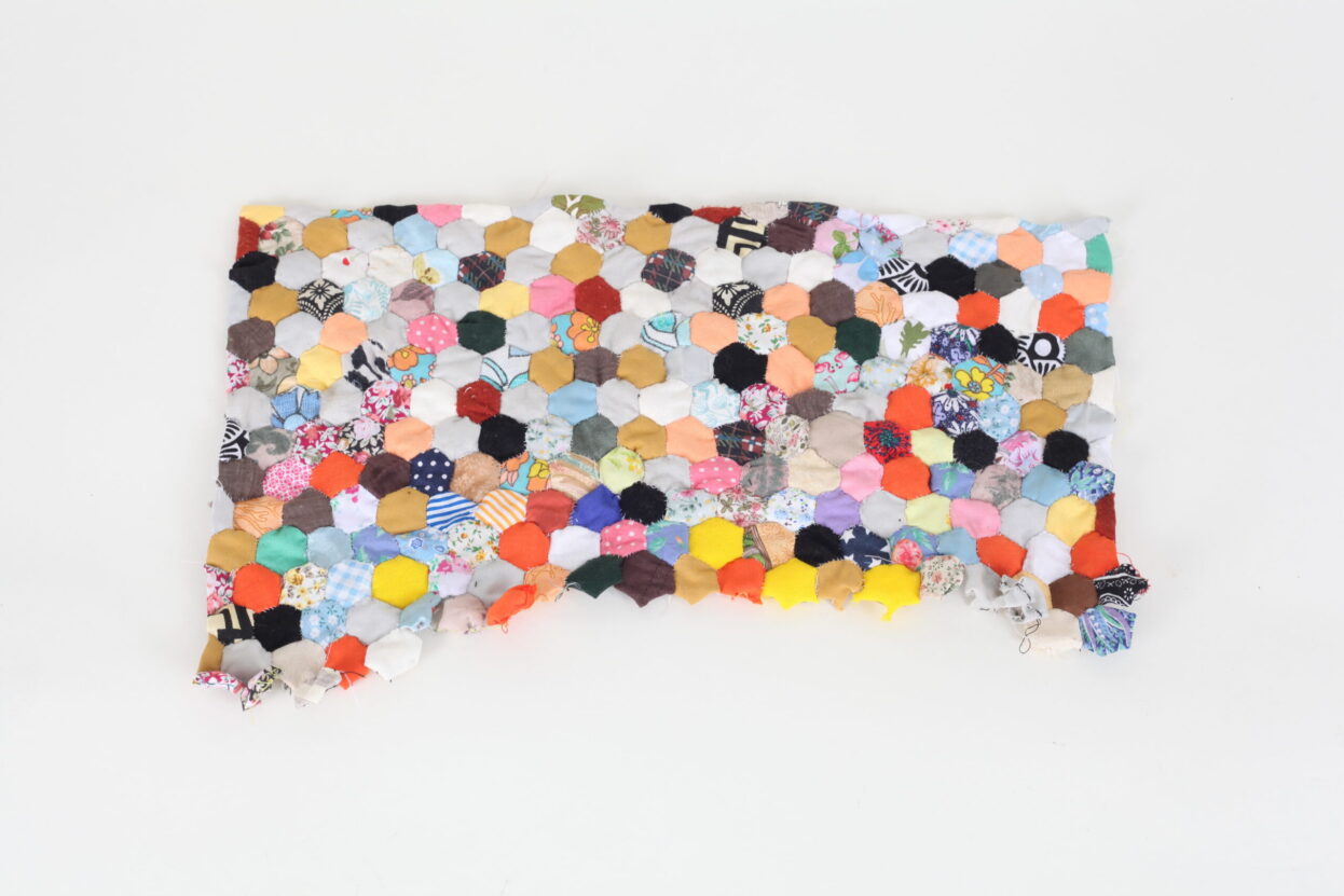 Patchwork made from many small hexagons of colourful fabric, by Sarah Lee