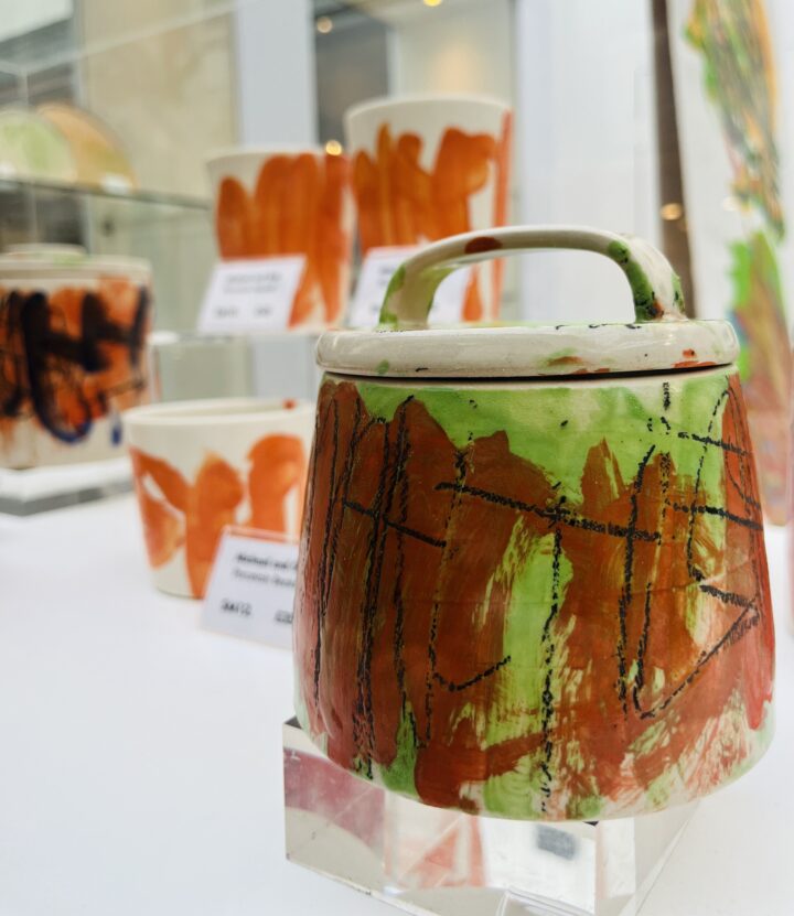 A ceramic pot in a glass case.