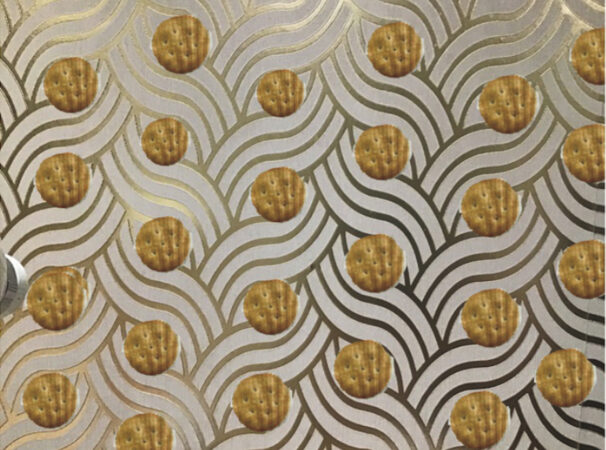 Repetitive, gold, wavy pattern with mini cheddar biscuits on top