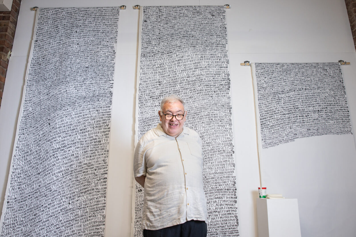 Artist Barry Finan stood in front of his long scrolls of text.