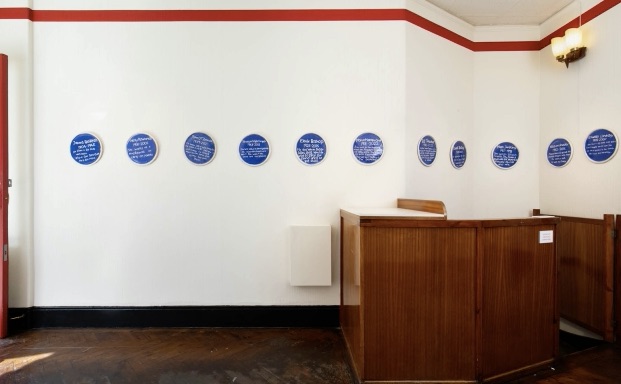 The gallery wall of the gallery of everthing displaying blue plaques.