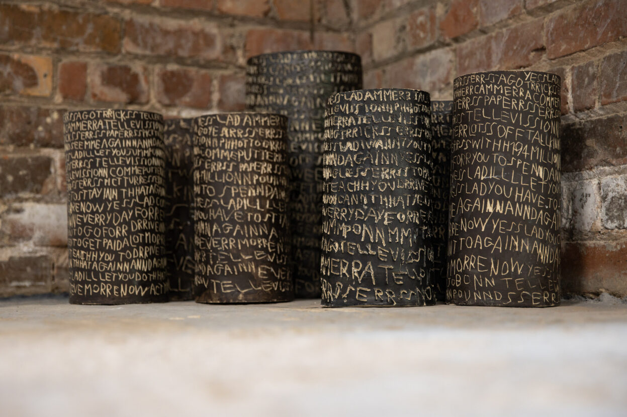 Ceramic cylinders covered in repetitive text