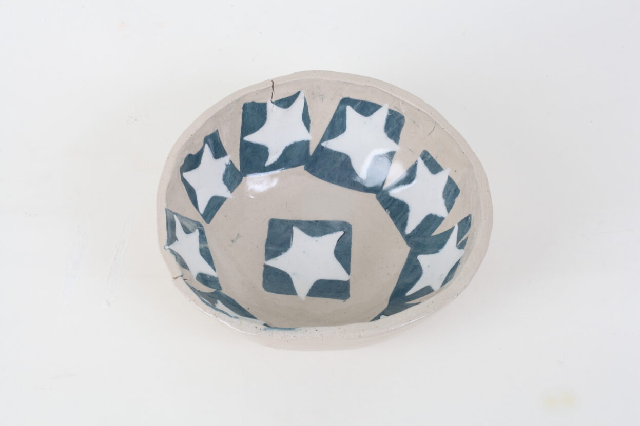 A ceramic bowl with blue and white stars on it.