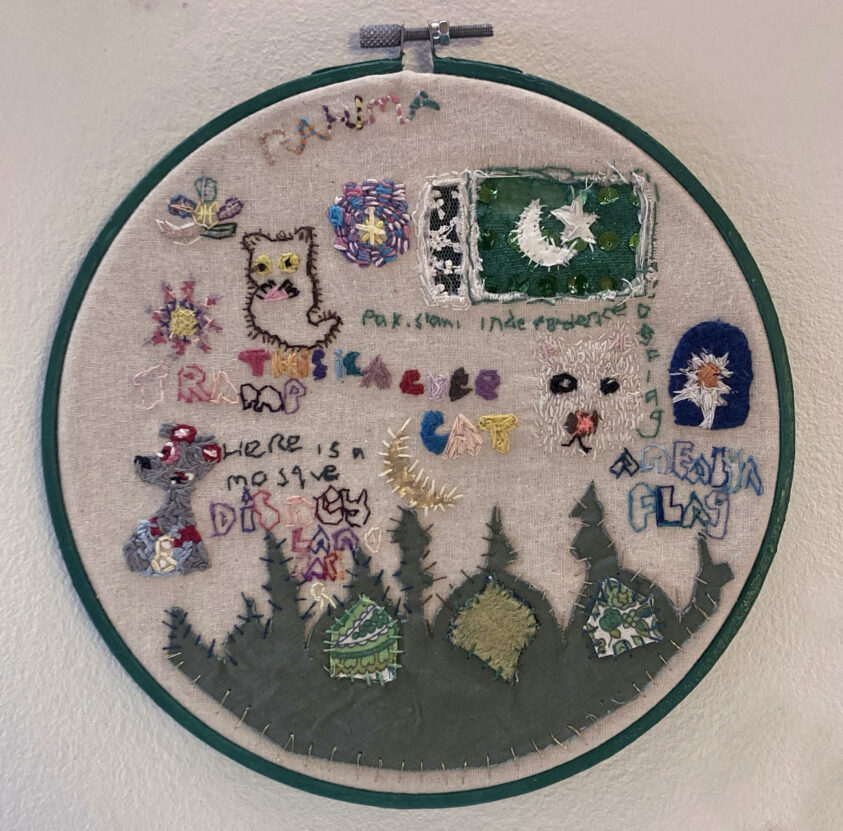 An embroidered artwork including animals, stars and flowers.