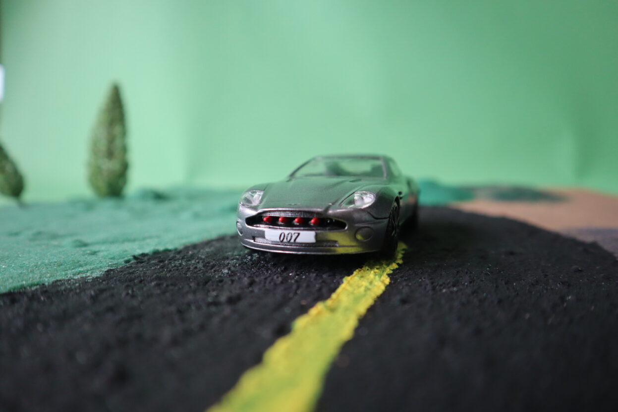 A photo of a model card on a model road against a green background.