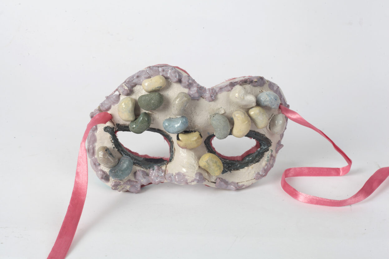 Ceramic theatrical mask with pink ribbons