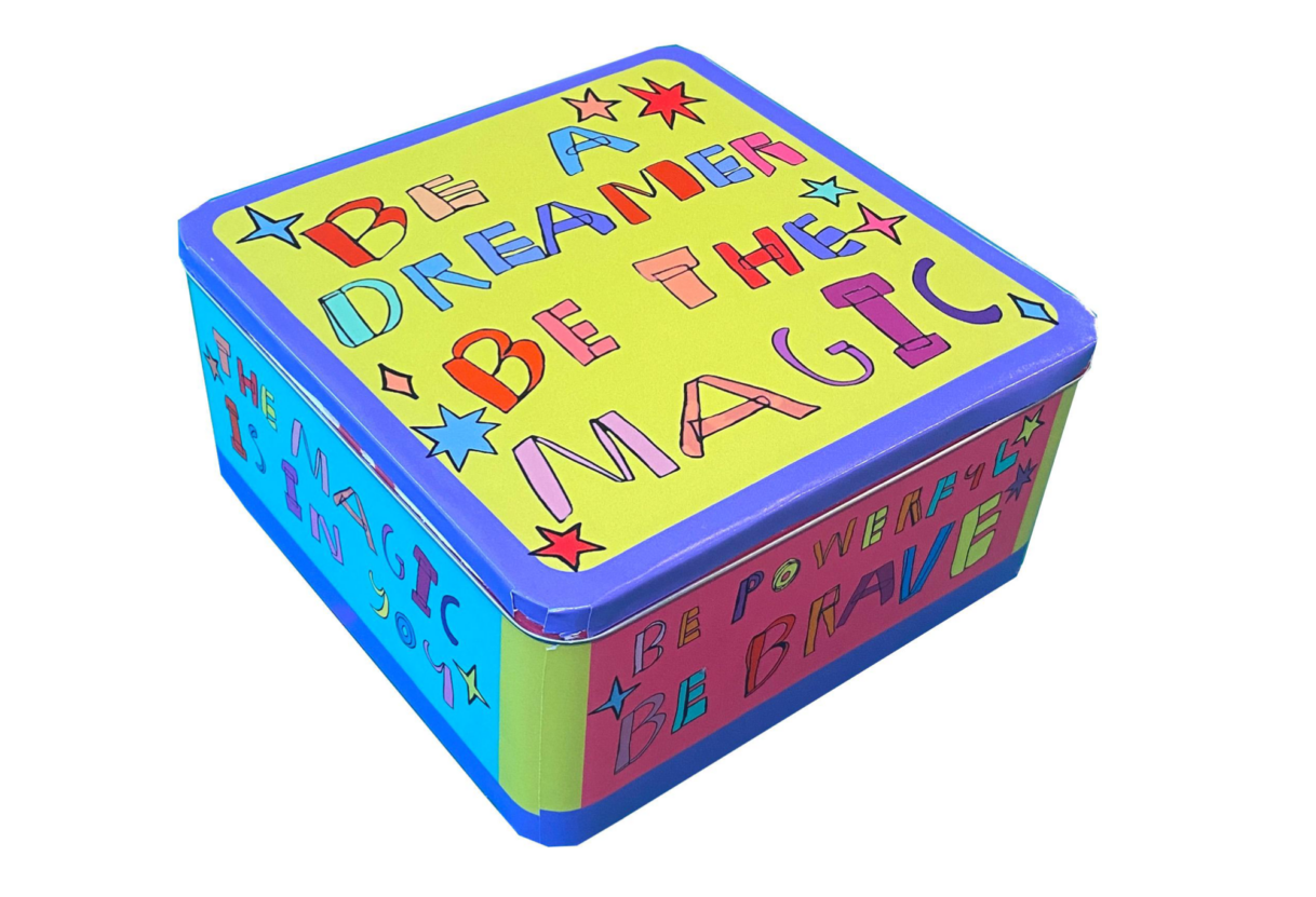 A colourful tin box with yext saying 'Be a dreamer, Be the magic' on the lid