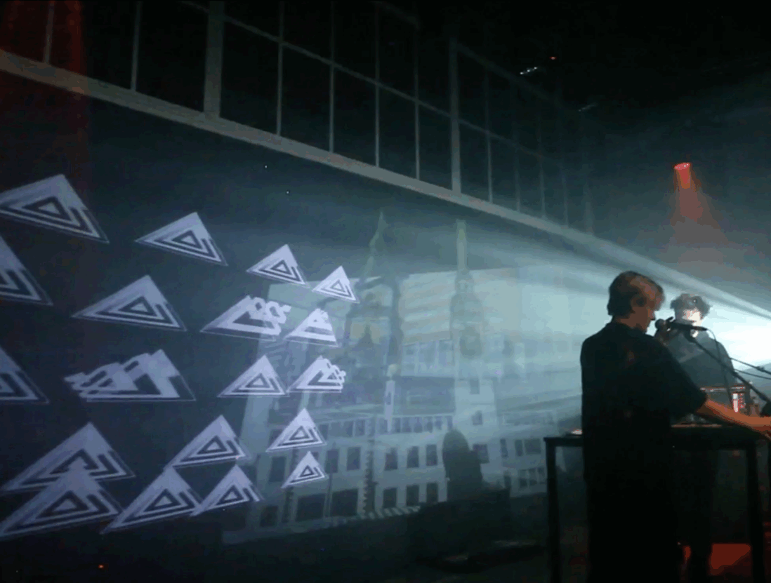 Projection mapping artwork against a black wall.