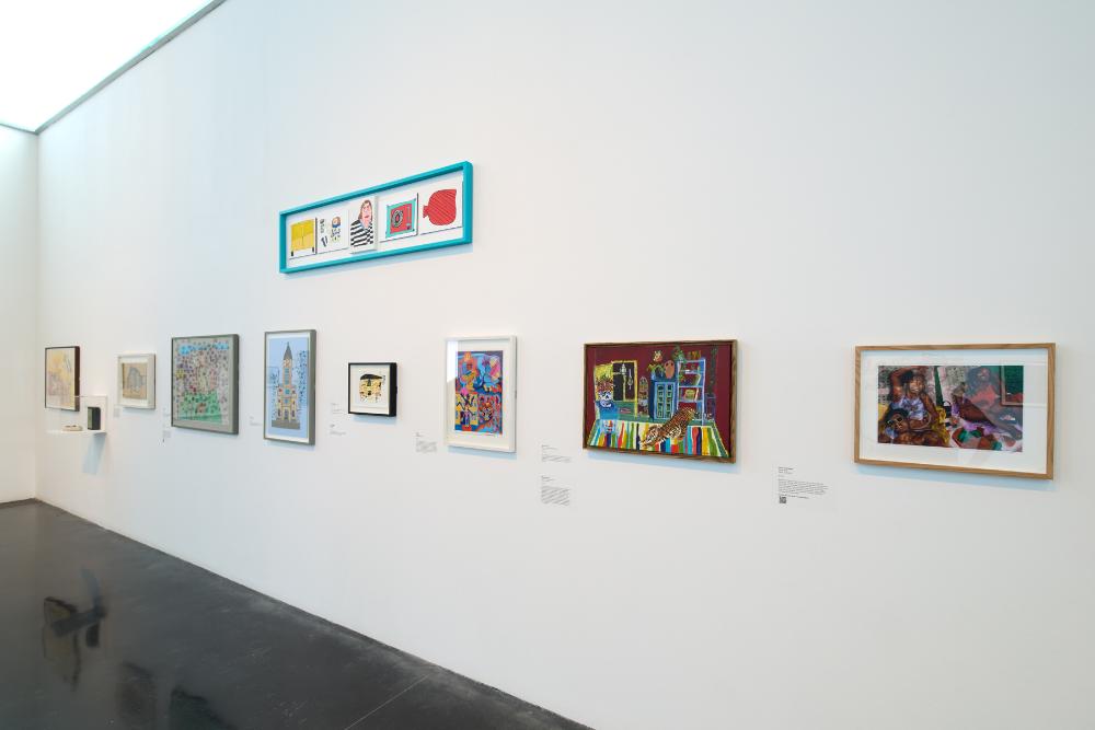 White art gallery wall with hung pictures.