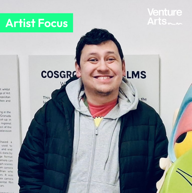 Venture Arts artist Justin Lees smiling at the Cosgrove Hall exhibition at Waterside.